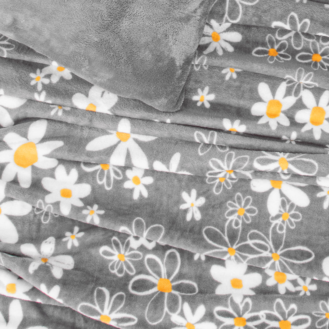 El Cobertor Merida, Es un hermoso cobertor de tonos gris y diseño con flores blancas.